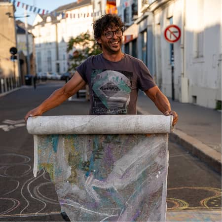 photo de Diego qui déroule une bande de papier peint en rigolant